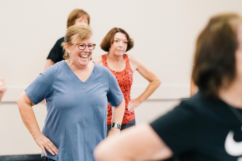 pexels photo 12086684 12086684 Happy middle-aged women participating in an indoor fitness class, promoting health and social interaction.